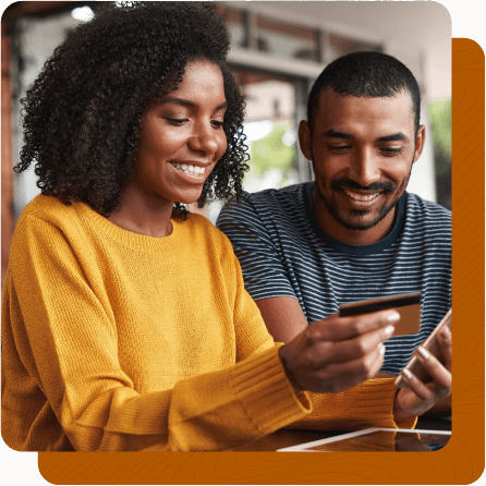 Young couple sitting side by side paying credit card on phone.