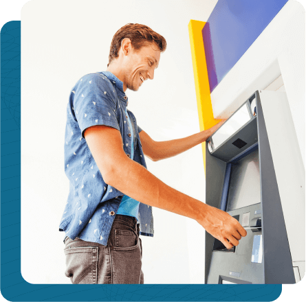 Man using ATM with big smile on his face.