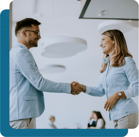 Male and Female business partners shaking hands in office meeting room.