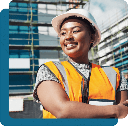 Smiling female utility worker with arms crossed, wearing hard hat and vest.