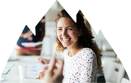 Happy female worker smiling at other coworker in meeting.