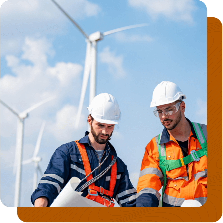 Two utility workers studying blueprint with windmills in the background.