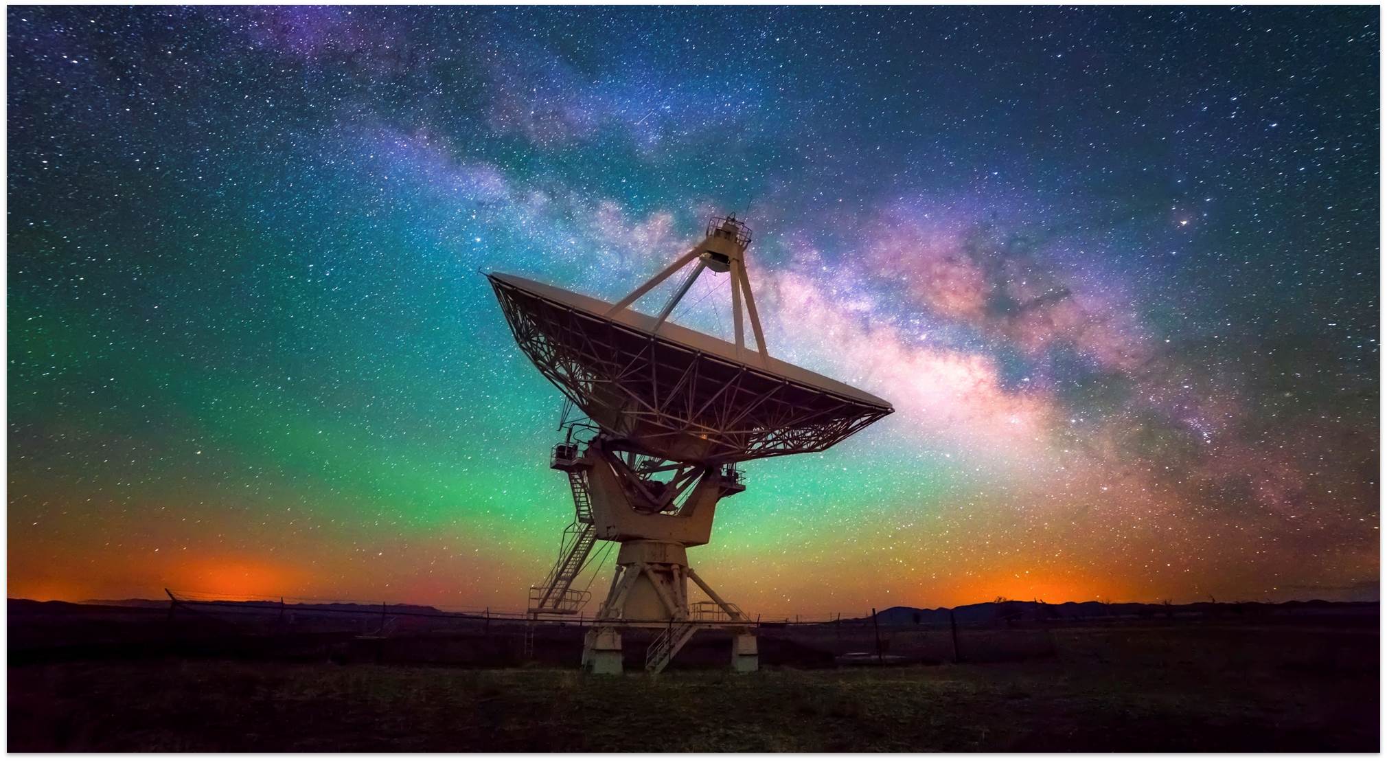 Signal dish in front of a starry, colorful sky