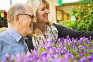 older people sniffing flowers