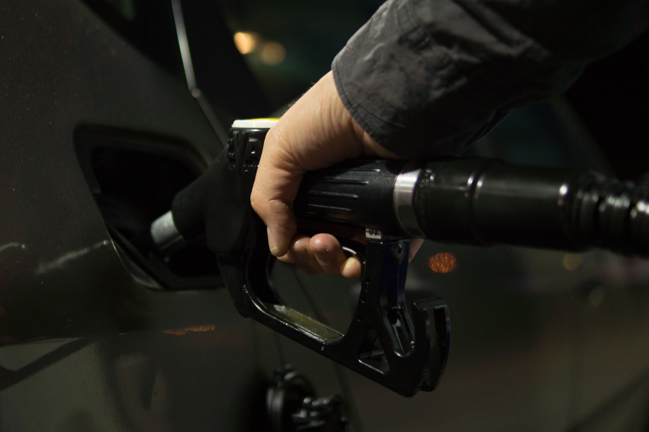 hand gripping a gas pump putting pump in car