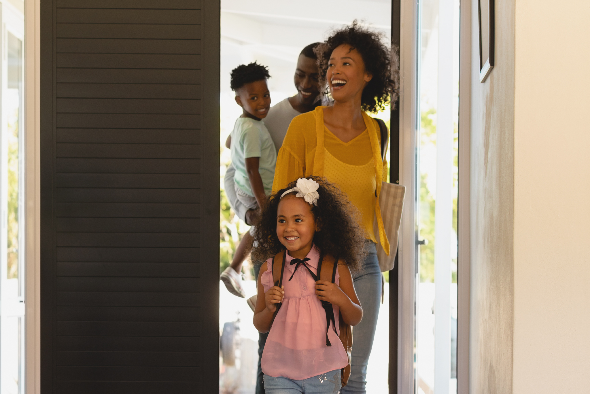 young happy family looking excited and awed as they enter a home