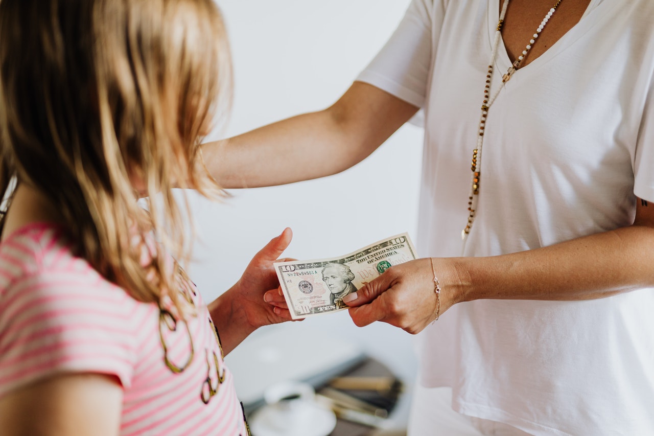 girl receiving money from parent